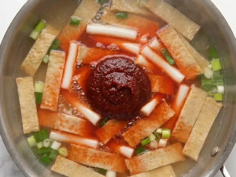 stirring gochujang sauce into a tteokbokki recipe