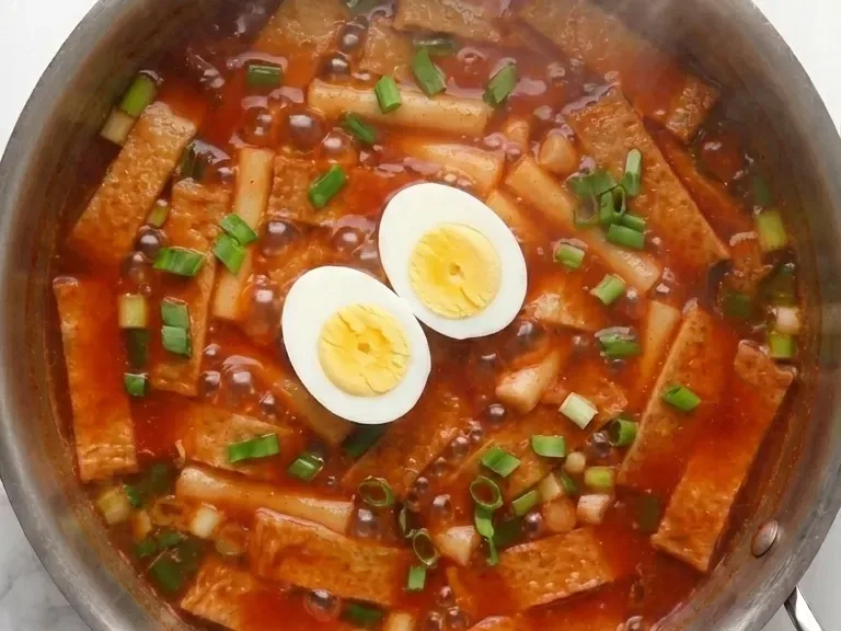 finished tteokbokki recipe topped with boiled eggs and green onion