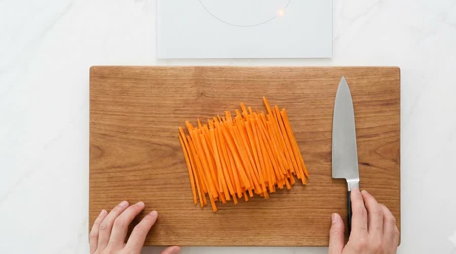 a big pile of julienned carrots on a cutting board for the kimbap recipe carrot oil
