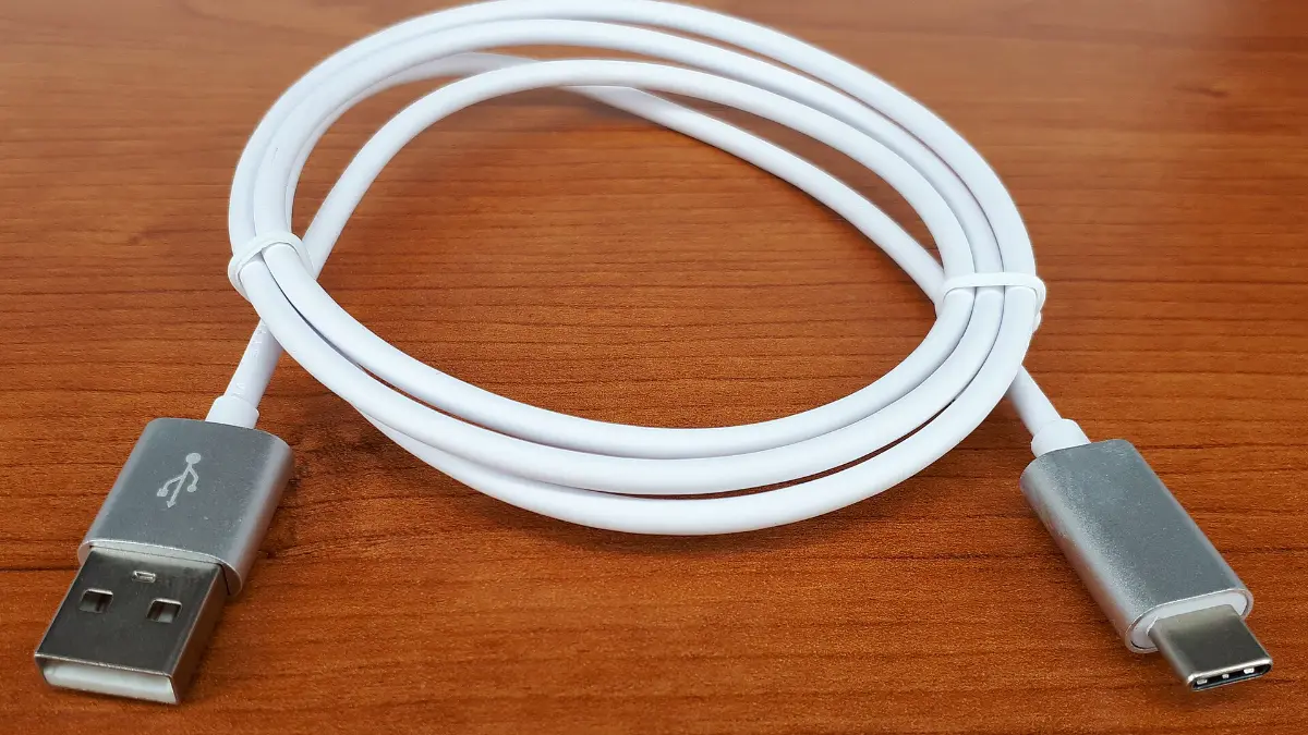 A single USB-C cable coiled on a desk, the backbone of a minimalist remote work setup