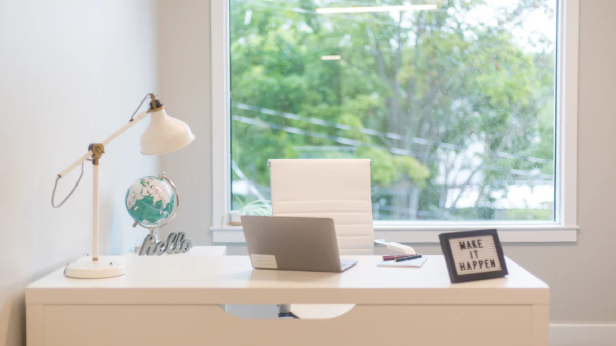 Minimalist remote work setup on a bright desk with a laptop and a single lamp
